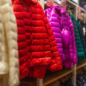 Vibrant winter jackets on display in a clothing store, showcasing a variety of colors for shoppers.