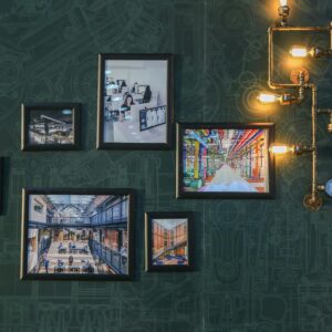 Industrial style wall art with vintage pipe lighting on a green textured wall adds a unique touch.