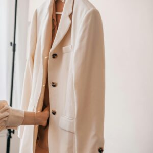 Stylish white blazer on display indoors with soft lighting.