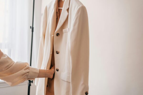Stylish white blazer on display indoors with soft lighting.
