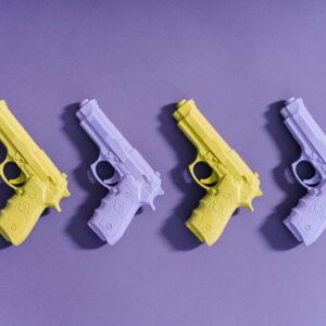 A set of colorful toy guns arranged on a vibrant purple surface for creative display.