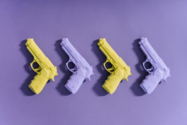 A set of colorful toy guns arranged on a vibrant purple surface for creative display.