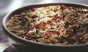 Macro shot of a ceramic bowl filled with colorful mixed wild rice, highlighting textures.
