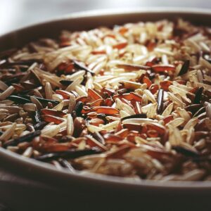 Macro shot of a ceramic bowl filled with colorful mixed wild rice, highlighting textures.