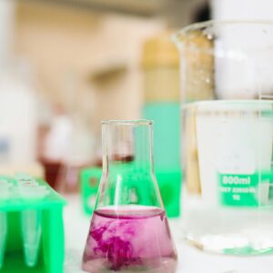 Chemistry lab with flask and beaker containing colorful solutions for experimental research.