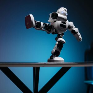 A modern robot toy balancing dynamically on one leg, set against a blue gradient background.