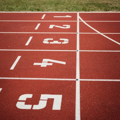 Close-up view of a red running track with numbered starting lanes, perfect for athletic themes.