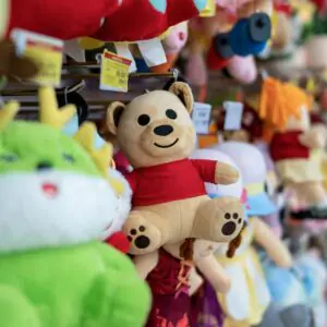 Colorful plush toys hanging in a lively retail store aisle.