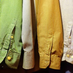 A row of vibrant, striped shirts hanging neatly, showcasing fashion variety.